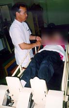 かかとの筋肉をを伸ばすための装置に横になるJTさん
